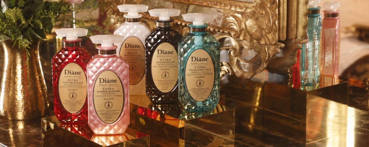 All five Extra shampoos on gold mirror plinths with flowers