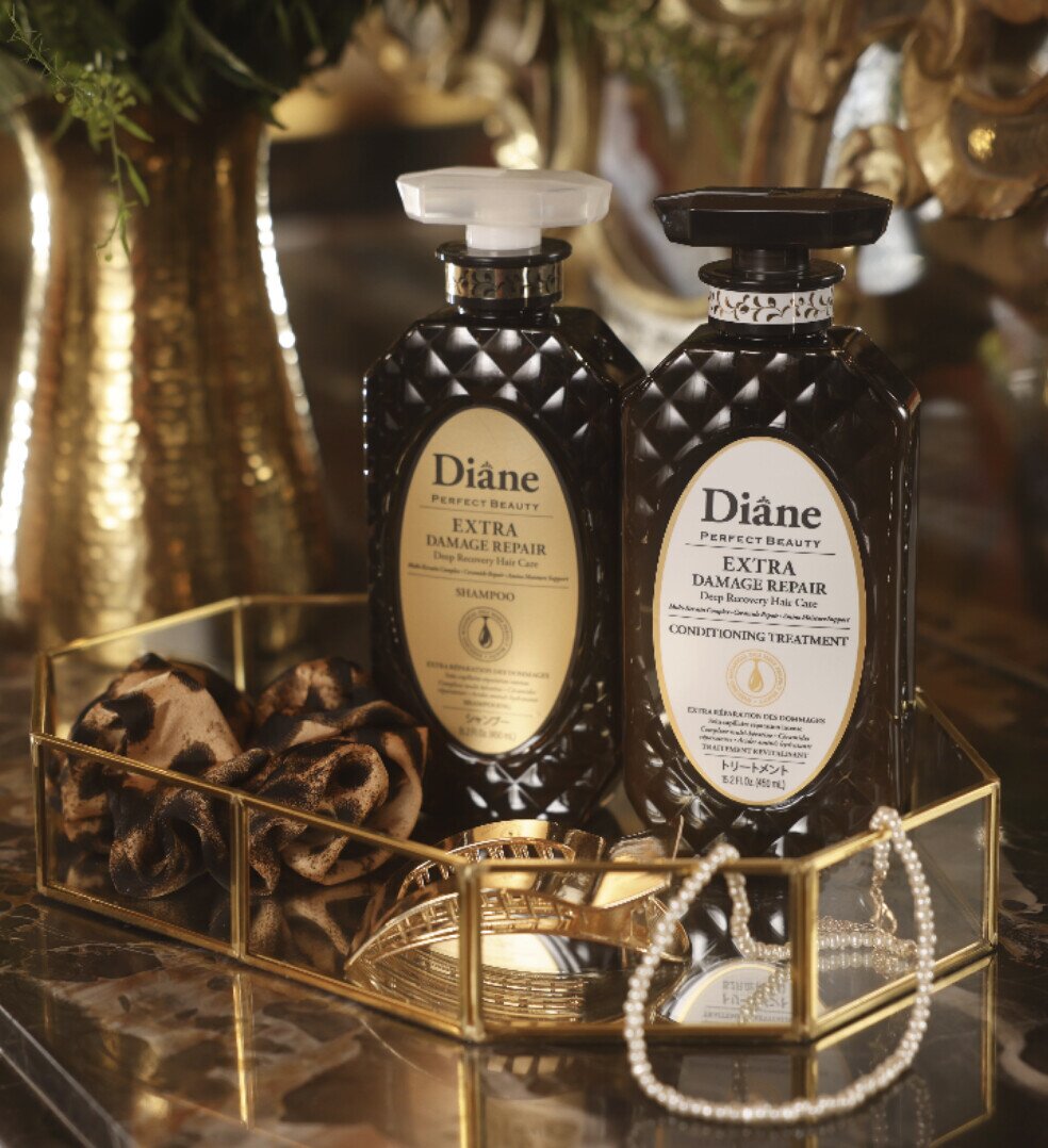 Extra Damage Repair Shampoo and Conditioning Treatment on a gold mirrored tray with pearls