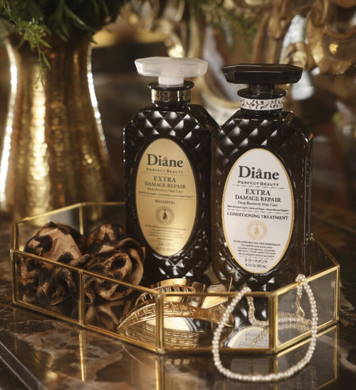 Extra Damage Repair Shampoo and Conditioning Treatment on a gold mirrored tray with pearls