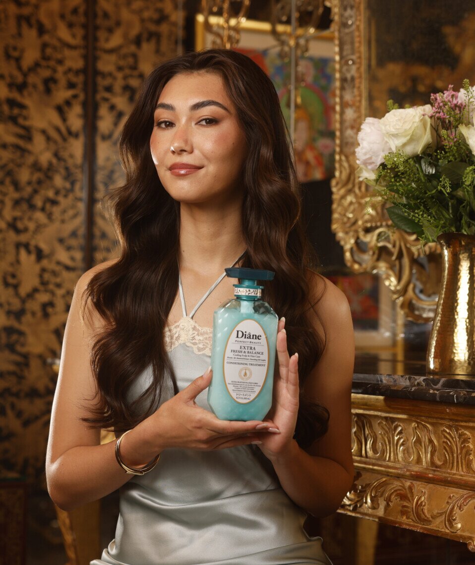 Model with long brunette waves holding Extra Fresh & Balance Conditioning Treatment