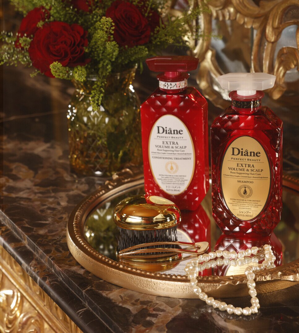 Extra Volume & Scalp Conditioning Treatment and Shampoo on a gold mirror tray with red roses