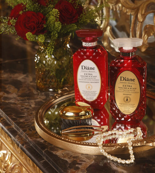 Extra Volume & Scalp Conditioning Treatment and Shampoo on a gold mirror tray with red roses